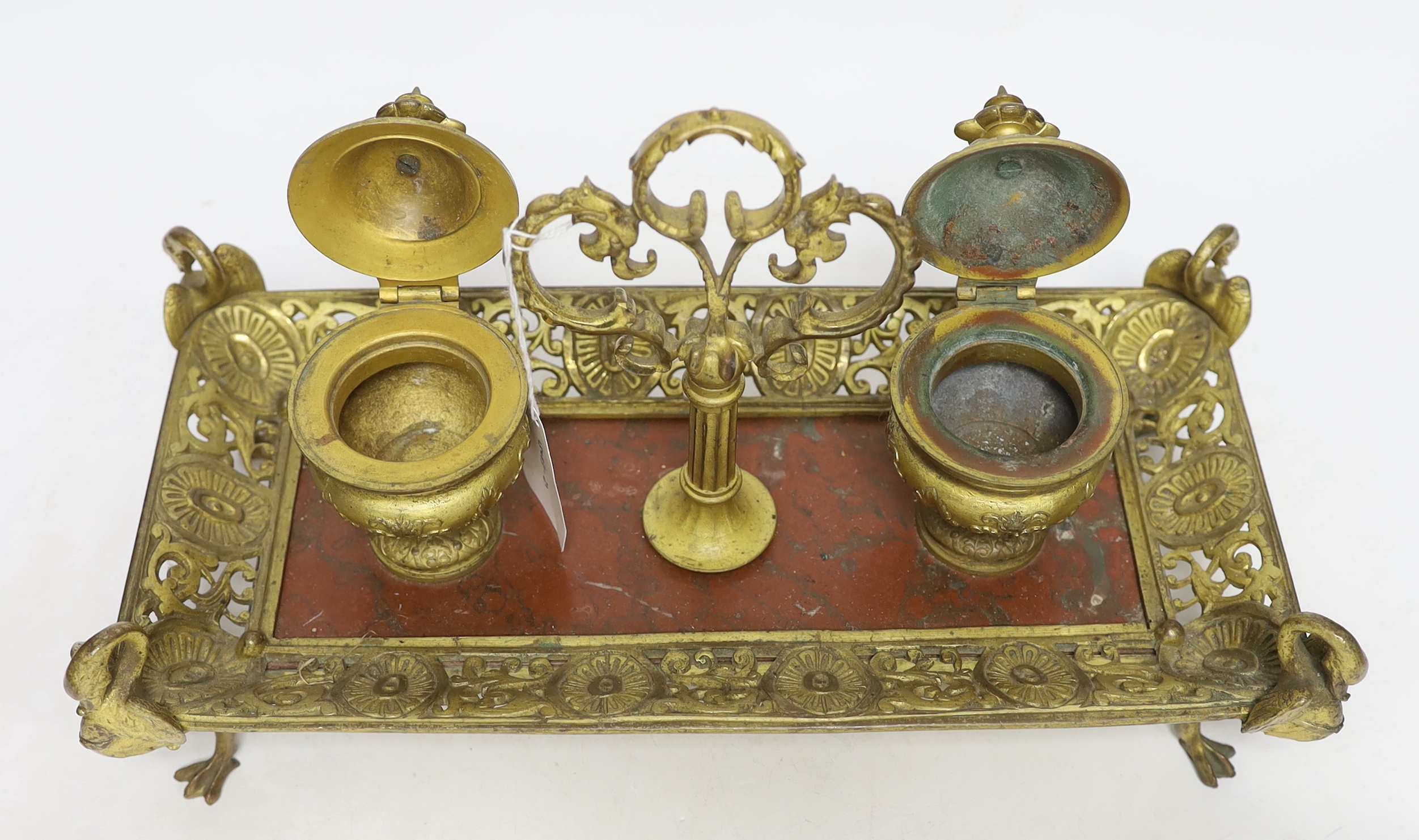 An ormolu inkstand with rouge marble base raised on four feet in the form of swans, 36cm wide